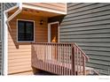 Front door entrance with a light wood porch, metal railing, and a window on the side at 2885 Springdale Ln, Boulder, CO 80303