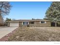 A ranch-style home with an attached garage, brick facade and mature landscaping in the front yard at 3045 Mcintosh Dr, Longmont, CO 80503