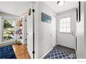 Bright entryway with hardwood floors, blue rug, white walls, and a window to the outdoors at 3209 Redstone Rd # 12B, Boulder, CO 80305