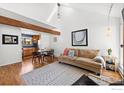 A sun-filled living room with light hardwood floors, and view into the dining and kitchen areas at 3209 Redstone Rd # 12B, Boulder, CO 80305