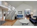 Bright foyer with grand staircase, hardwood floors, and views into the living and dining areas at 366 Blackhawk Ln, Lafayette, CO 80026