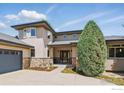 Charming home featuring stone accents, a covered entry, and lush landscaping at 4405 Fairway Ln, Broomfield, CO 80023