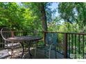 Outdoor dining set on a wooden deck with railing overlooking a creek and lush greenery creates a relaxing atmosphere at 531 Arapahoe Ave, Boulder, CO 80302