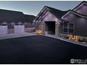 Stunning home exterior featuring stone accents, modern lighting, and a spacious driveway leading to attached garages at 5489 Country Club Dr, Larkspur, CO 80118