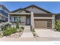 Modern home showcasing stone and panel siding, complemented by a beautifully landscaped front yard at 5626 Four Leaf Dr, Longmont, CO 80503