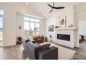 Bright living room with a stone fireplace, large windows, and modern decor at 5626 Four Leaf Dr, Longmont, CO 80503