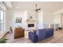 Open living room featuring high ceilings, modern furnishings, a stone fireplace, and hardwood floors at 5626 Four Leaf Dr, Longmont, CO 80503