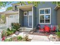 Cozy front porch with space to relax, surrounded by a charming garden and a white picket fence at 588 Beauprez Ave, Lafayette, CO 80026