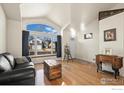 Inviting living area with a large window, a leather sofa, and hardwood floors at 908 Cinnamon Ln, Louisville, CO 80027