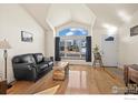 Bright living room with hardwood floors, vaulted ceilings, and large windows at 908 Cinnamon Ln, Louisville, CO 80027