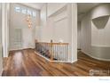 Open foyer with wood floors, high ceilings, and stairs with an iron and wood banister at 9150 Ferncrest St, Firestone, CO 80504