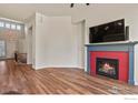 Comfortable living room with wood floors, fireplace, and adjacent staircase at 9150 Ferncrest St, Firestone, CO 80504