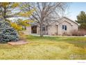 Charming single-story brick home with manicured lawn, mature trees, and inviting front entrance at 115 Grand View Dr, Mead, CO 80542