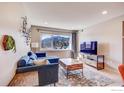 Bright living room with a blue sofa, wooden coffee table, and mountain views through a large window at 1201 Balsam Ave # 203, Boulder, CO 80304