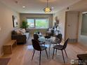 Bright living room featuring modern furniture, a decorative light fixture, and a large window with a lush green view at 1201 Balsam Ave # 203, Boulder, CO 80304