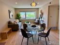 Bright living room featuring modern furniture, a decorative light fixture, and a large window with a lush green view at 1201 Balsam Ave # 203, Boulder, CO 80304