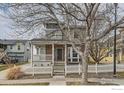 Charming two-story home with a covered front porch, showcasing its brick accents and curb appeal at 14031 Blue River Trl, Broomfield, CO 80023