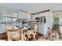 Bright kitchen features white cabinetry, stainless steel appliances, granite countertops, and hardwood flooring at 14031 Blue River Trl, Broomfield, CO 80023