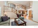 Spacious living room with a soaring ceiling, elegant staircase, and large windows providing ample natural light at 14180 Whitney Cir, Broomfield, CO 80023