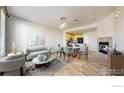 Open-concept living room featuring a modern fireplace, dining area, and seamless flow to the kitchen at 16047 E Geddes Ln # 128, Aurora, CO 80016