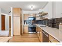 Contemporary kitchen features light wood cabinetry, stainless steel appliances, quartz countertops and a black tiled backsplash at 1850 Folsom St # 1012, Boulder, CO 80302