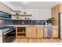 Modern kitchen featuring stainless steel appliances, dark backsplash, and open shelving with quartz countertops at 1850 Folsom St # 1012, Boulder, CO 80302