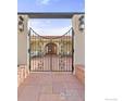 Wrought iron gate leading to a private courtyard with seating area, featuring a tile roof at 2895 Iliff St, Boulder, CO 80305