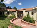 Landscaped courtyard featuring a tiled walkway, wrought iron gate, and colorful flower beds at 2895 Iliff St, Boulder, CO 80305