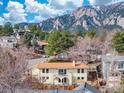 Back exterior of a tan two-story home featuring a small balcony and mountain views at 2895 Iliff St, Boulder, CO 80305