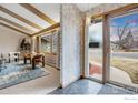 View of the house entryway leading to the living room with exposed beams and large windows at 350 Hopi Pl, Boulder, CO 80303