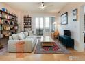 Bright living room featuring hardwood floors, stylish furniture, and built-in shelving with an adjacent balcony at 3701 Arapahoe Ave # 304, Boulder, CO 80303