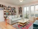 Cozy living room with a comfortable couch, decorative rug, bookshelves, and balcony access at 3701 Arapahoe Ave # 304, Boulder, CO 80303