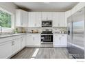 Modern kitchen with stainless steel appliances, granite countertops, and sleek white cabinetry at 3727 Castle Peak Ave, Superior, CO 80027