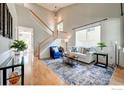 Bright living room featuring vaulted ceiling, hardwood floors, a staircase, and ample natural light at 3727 Castle Peak Ave, Superior, CO 80027