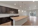 Modern kitchen features an expansive island with granite countertops, dark cabinetry, and stainless steel appliances at 415 Primrose Ln, Superior, CO 80027