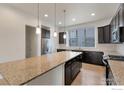 A spacious kitchen with granite countertops, dark cabinets, stainless steel appliances, and modern pendant lighting at 415 Primrose Ln, Superior, CO 80027