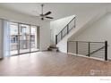 A well-lit living room showcasing wood floors, a staircase with a black metal railing, and access to a sliding glass door at 415 Primrose Ln, Superior, CO 80027