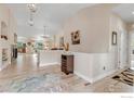 Bright foyer featuring hardwood floors, multiple chandeliers, archways, and a view into the living spaces beyond at 462 Blue Lake Trl, Lafayette, CO 80026