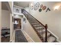 Elegant foyer with a staircase featuring iron railings and decorative wall accents at 6834 Blue Spruce St, Frederick, CO 80530