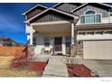 Inviting covered front porch with stone accents and space for seating near the front door at 6834 Blue Spruce St, Frederick, CO 80530