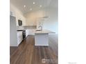 Bright kitchen features wood floors, white cabinets, stainless steel appliances, and a center island at 729 Kubat Ln # A, Longmont, CO 80503