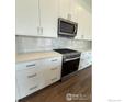 Kitchen features stainless steel range, microwave, tile backsplash and quartz countertops at 729 Kubat Ln # A, Longmont, CO 80503