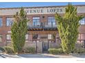 Close up of the brick Avenue Lofts building exterior with black iron balconies and decorative shrubbery at 1000 E 18Th Ave, Denver, CO 80218