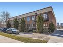 Brick building exterior with mature green landscaping and convenient parking at the Avenue Lofts at 1000 E 18Th Ave, Denver, CO 80218