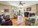 Cozy living room featuring a fireplace, large windows, and comfortable seating at 1038 Petras St, Erie, CO 80516