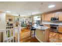 Open-concept layout featuring hardwood floors connecting the kitchen, dining, and living areas at 1038 Petras St, Erie, CO 80516