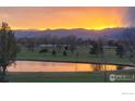 A serene view of a lake at sunset reflecting the warm colors of the sky at 1143 Purdue Dr, Longmont, CO 80503