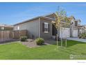 This home features neutral-toned siding, complemented by a lush lawn and simple landscaping, presenting a tidy exterior view at 1152 Payton Ave, Fort Lupton, CO 80621