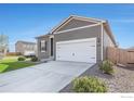 This property boasts neutral-toned siding, complemented by a manicured lawn and simple landscaping, including a spacious driveway at 1152 Payton Ave, Fort Lupton, CO 80621