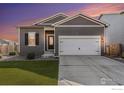 Charming single-story home featuring a well-kept lawn, two car garage, and neutral-toned siding against a beautiful sunset sky at 1152 Payton Ave, Fort Lupton, CO 80621